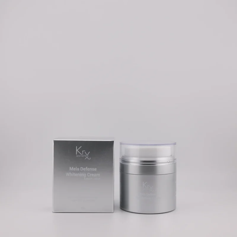 Produktbild der KrX Mela Defense Whitening Cream – Silberne Verpackung mit Spender und Umverpackung, geeignet zur Behandlung von Pigmentflecken bei allen Hauttypen.