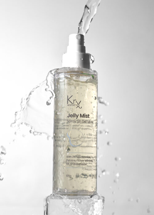 Flasche der KrX Jelly Mist Spray-On Gel Mask – stehend auf Eisblock, mit Wasser umgeben, klarer Gel-Inhalt sichtbar – Symbolbild für Feuchtigkeit & Frische.