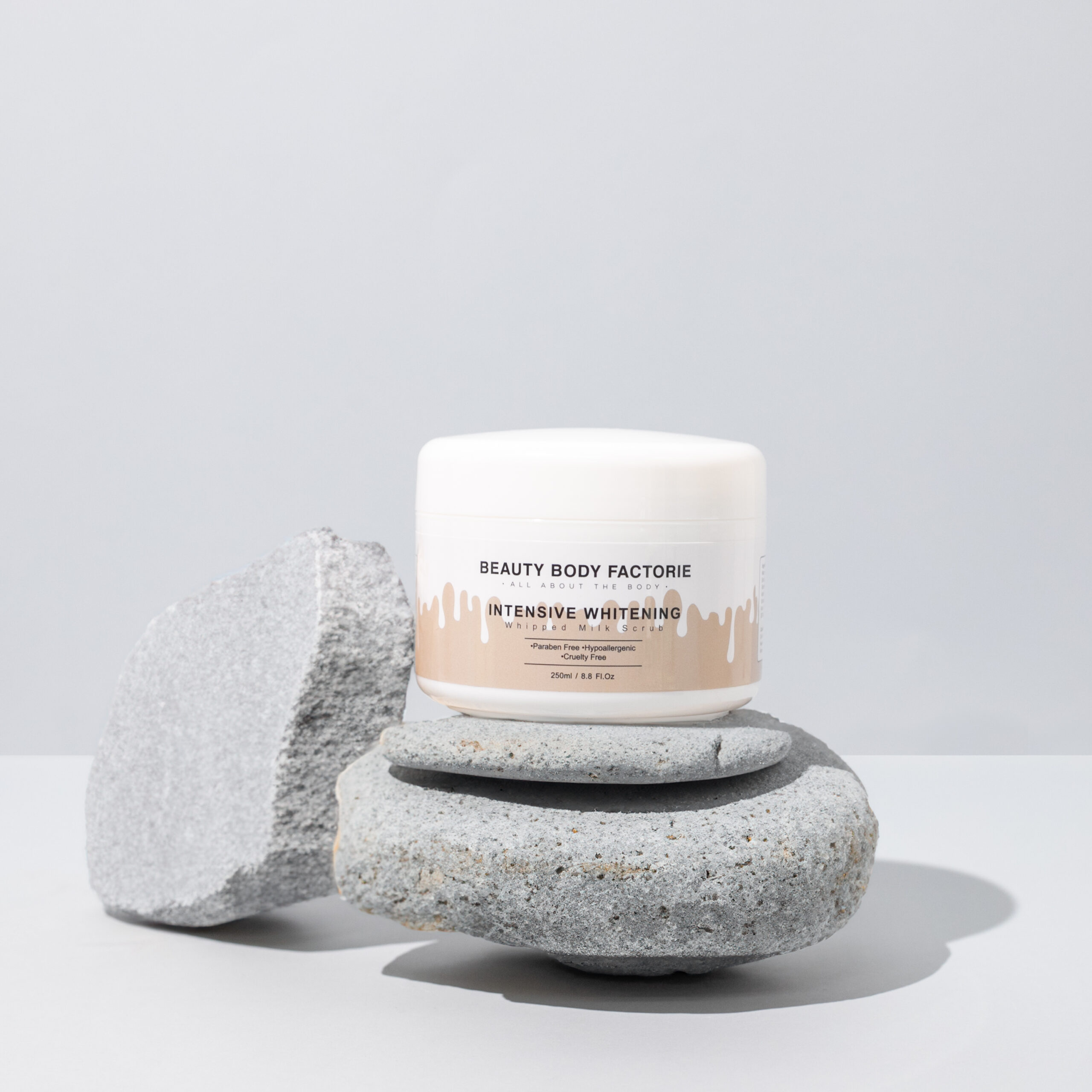 Intensiv aufhellendes Milch-Körperpeeling Intensiv aufhellendes Milch-Körperpeeling von Beauty Body Factorie auf grauen Steinen